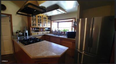 kitchen featuring sink, black appliances, and exhaust hood