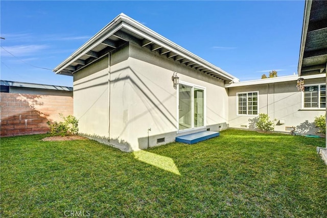 rear view of property featuring a yard