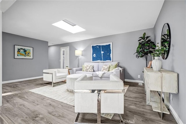 living room with hardwood / wood-style floors and a skylight