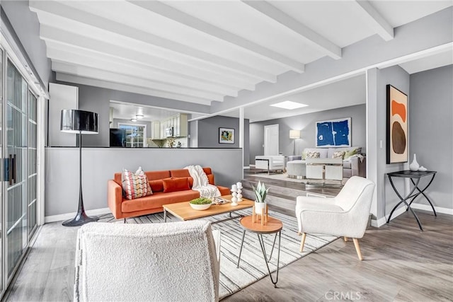 living room with beamed ceiling and wood-type flooring