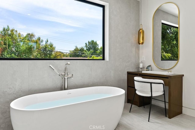 bathroom with a tub and vanity