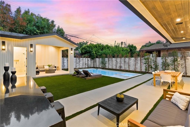 patio terrace at dusk featuring a lawn, an outdoor living space, and a fenced in pool