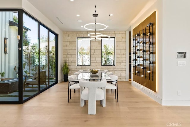 interior space with brick wall, a wealth of natural light, and light hardwood / wood-style flooring