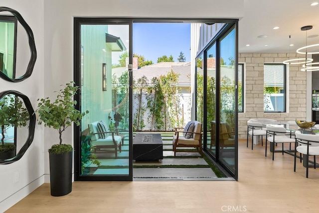 doorway featuring light hardwood / wood-style floors, a wealth of natural light, and an inviting chandelier