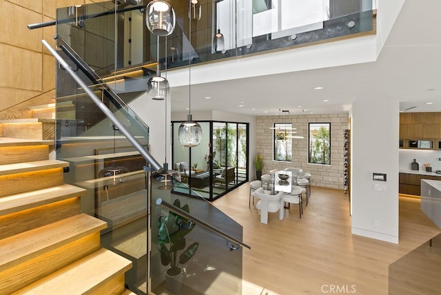 staircase with wood-type flooring and a high ceiling