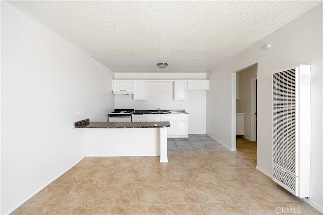 kitchen featuring white range, kitchen peninsula, sink, white cabinets, and a textured ceiling