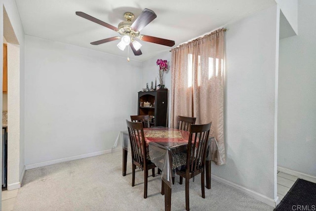 carpeted dining room featuring ceiling fan