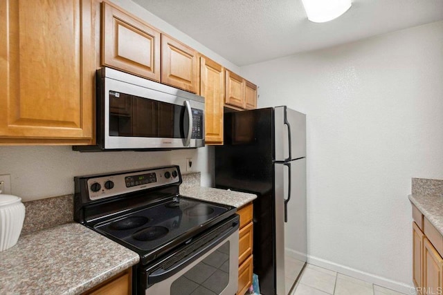 kitchen featuring light tile patterned flooring and stainless steel appliances