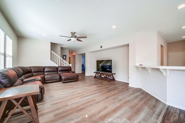 living room featuring ceiling fan and light hardwood / wood-style floors