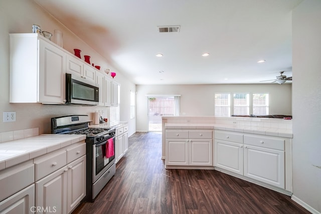 kitchen with tile countertops, dark hardwood / wood-style flooring, white cabinets, and stainless steel appliances