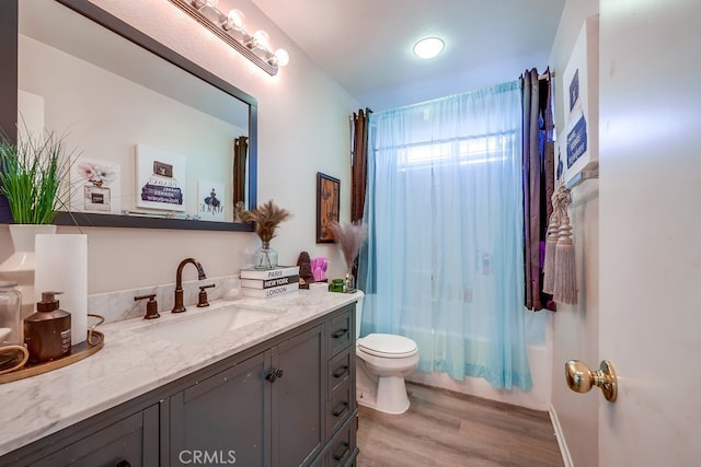 full bathroom featuring hardwood / wood-style flooring, vanity, toilet, and shower / bath combo with shower curtain