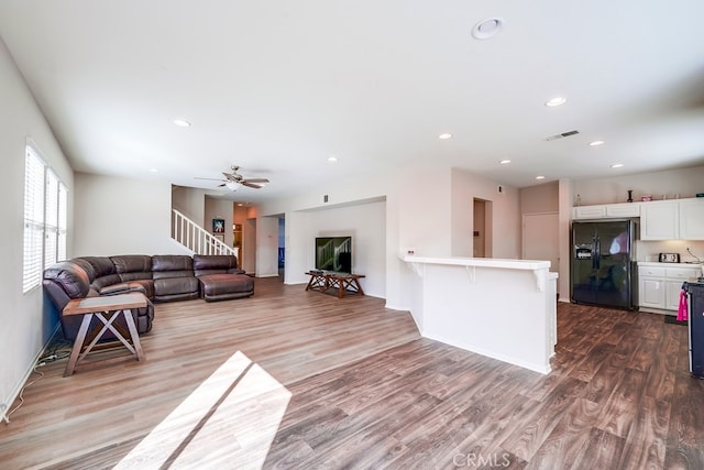 living room featuring hardwood / wood-style floors and ceiling fan