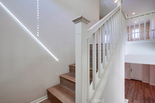 stairs with a high ceiling and hardwood / wood-style flooring