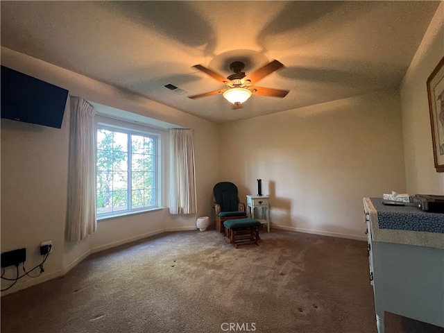 sitting room with dark carpet and ceiling fan