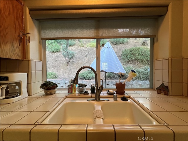 details with tile countertops, tasteful backsplash, and sink