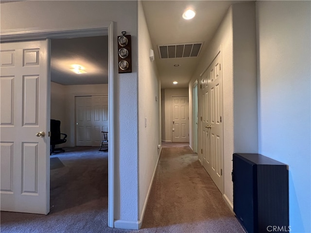 hall featuring dark colored carpet