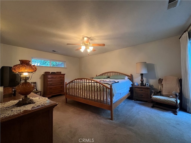 carpeted bedroom with a textured ceiling and ceiling fan