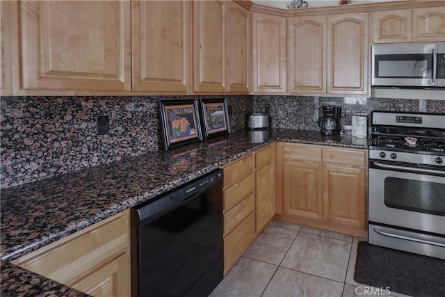 kitchen featuring stainless steel appliances, backsplash, dark stone countertops, light tile patterned floors, and light brown cabinetry