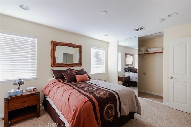 bedroom with multiple windows and light colored carpet