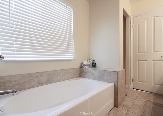 bathroom with tile patterned floors and a tub