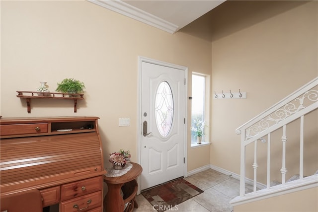 foyer entrance with crown molding and light tile patterned flooring