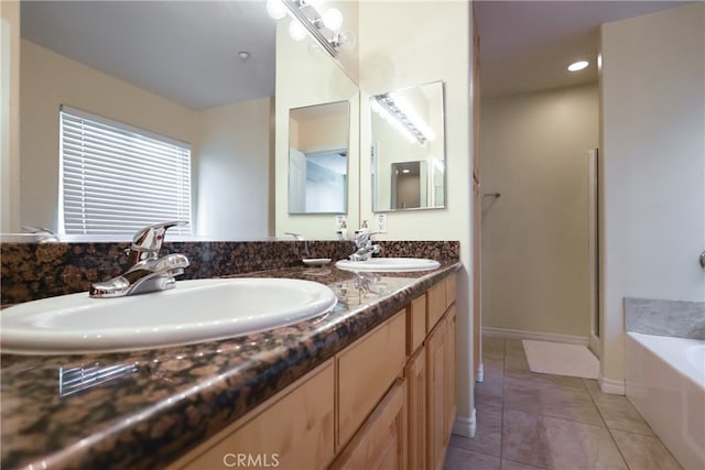 bathroom featuring vanity, a washtub, and tile patterned flooring