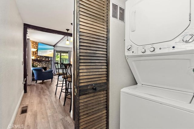 760 Blue Jay Rd Unit 10, Big Bear Lake, CA 92315 - laundry room with stacked washer / dryer, light wood-style flooring, baseboards, and a fireplace