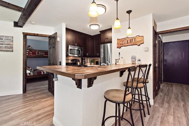 760 Blue Jay Rd Unit 10, Big Bear Lake, CA 92315 - kitchen featuring appliances with stainless steel finishes, wooden counters, light wood-style floors, and a breakfast bar
