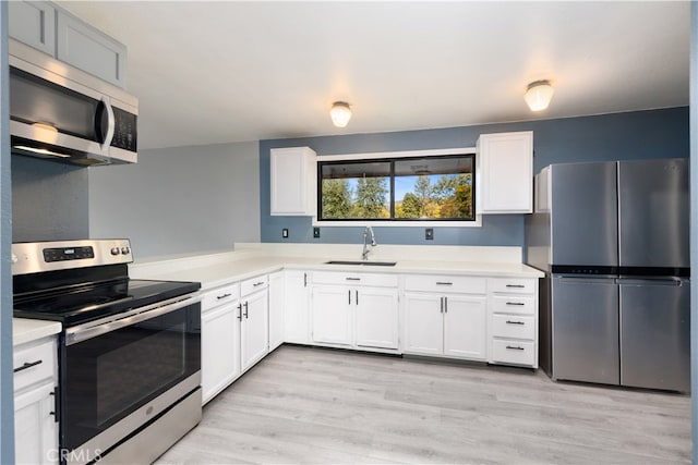 kitchen featuring light hardwood / wood-style flooring, white cabinets, stainless steel appliances, and sink