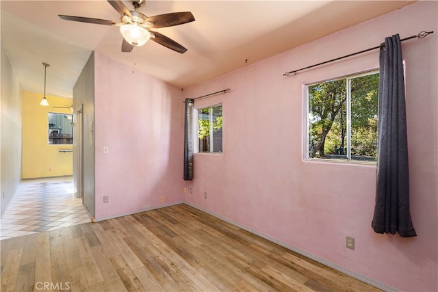 unfurnished room with lofted ceiling, light wood-type flooring, and ceiling fan