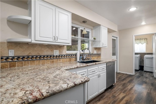 kitchen with washing machine and dryer, white cabinetry, dishwasher, and sink