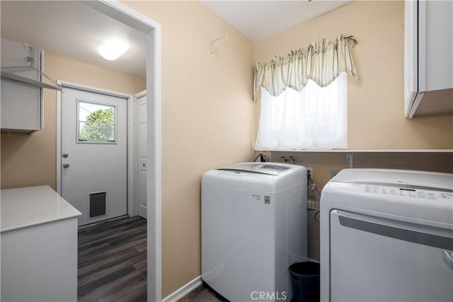 laundry area featuring washing machine and dryer, dark wood-type flooring, and cabinets