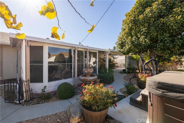 exterior space with a patio area, a sunroom, and a hot tub