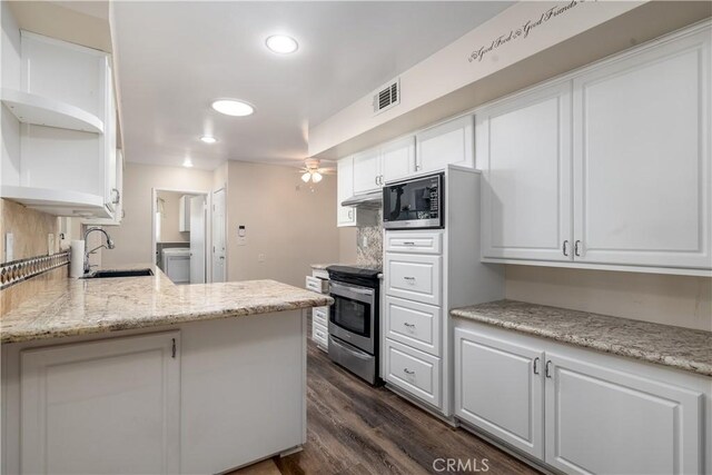 kitchen with kitchen peninsula, appliances with stainless steel finishes, dark hardwood / wood-style flooring, sink, and white cabinetry