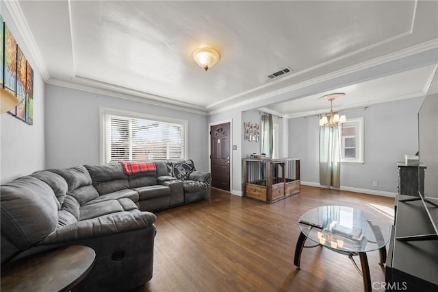 living room with dark hardwood / wood-style flooring, crown molding, and a notable chandelier