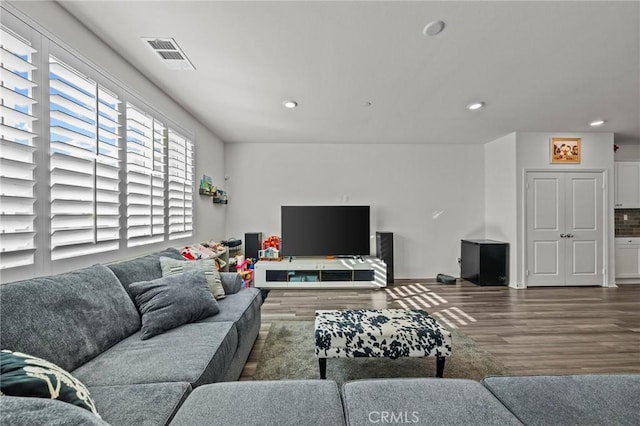 living area with recessed lighting, visible vents, and wood finished floors