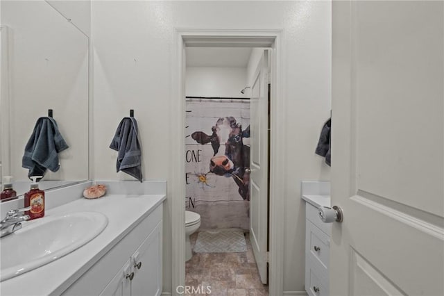 bathroom featuring stone finish floor, toilet, vanity, and a shower with curtain