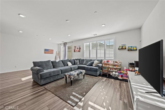 living room with recessed lighting and wood finished floors