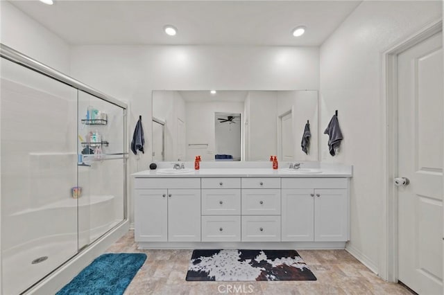 full bathroom with double vanity, a stall shower, and a sink