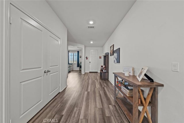 hallway with visible vents, recessed lighting, dark wood-type flooring, and baseboards