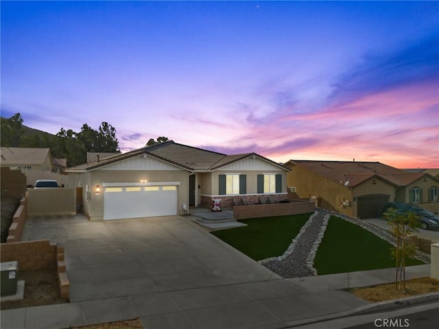 ranch-style home featuring a tiled roof, concrete driveway, stucco siding, a garage, and a gate