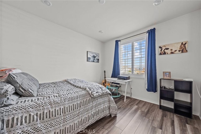 bedroom with baseboards and wood finished floors