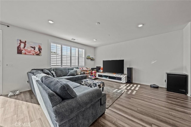 living area featuring recessed lighting, visible vents, baseboards, and wood finished floors