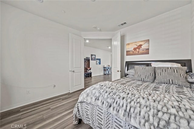 bedroom featuring visible vents, baseboards, and wood finished floors