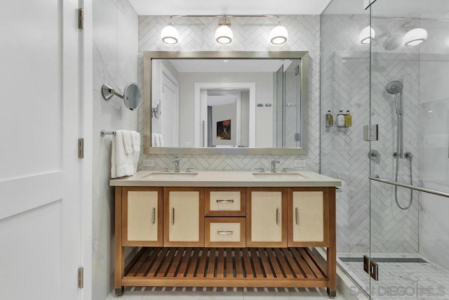 bathroom with vanity, tasteful backsplash, and a shower with shower door