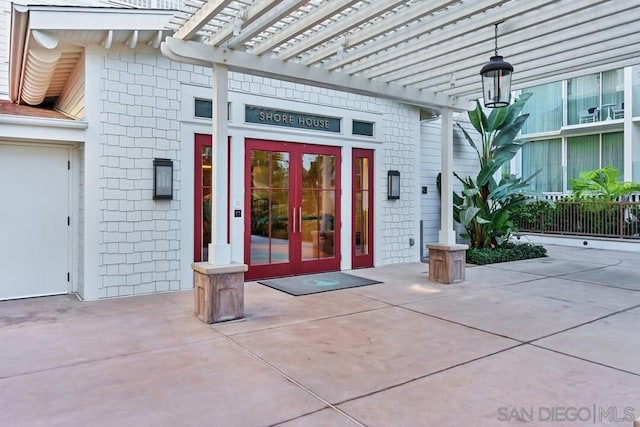 doorway to property featuring french doors and a pergola