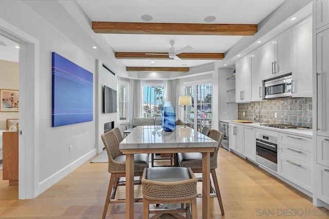 kitchen with light hardwood / wood-style floors, white cabinetry, and stainless steel appliances