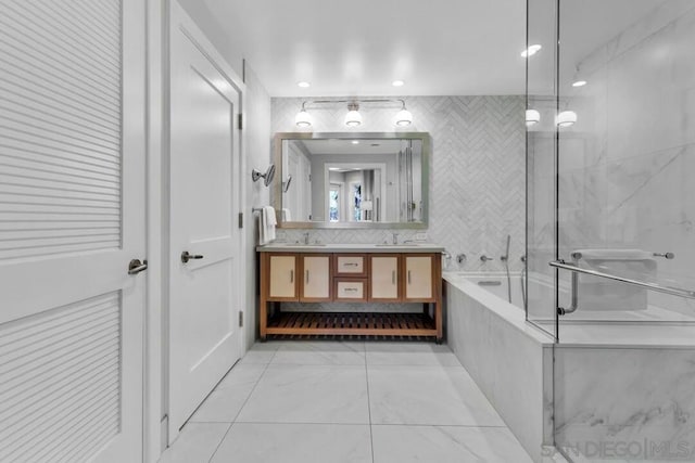 bathroom with vanity and tiled tub