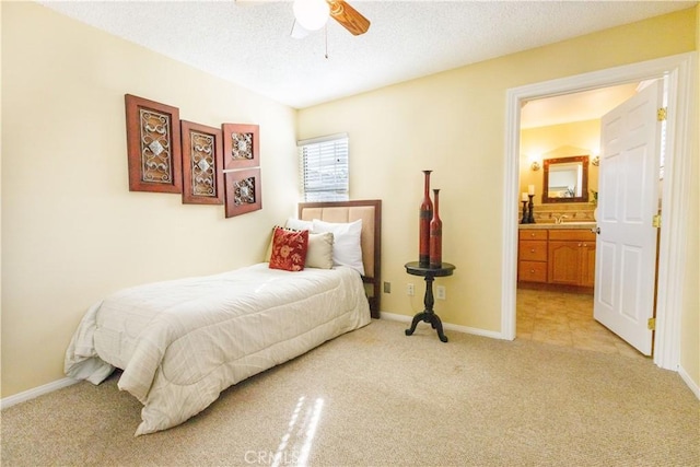 carpeted bedroom with connected bathroom, ceiling fan, sink, and a textured ceiling