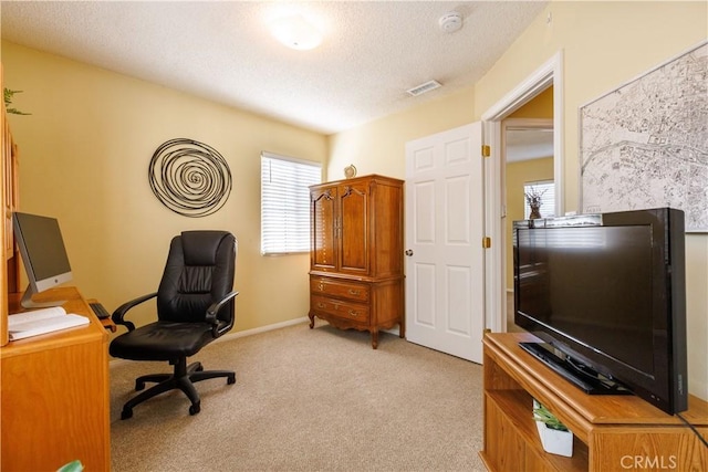 office area featuring light carpet and a textured ceiling